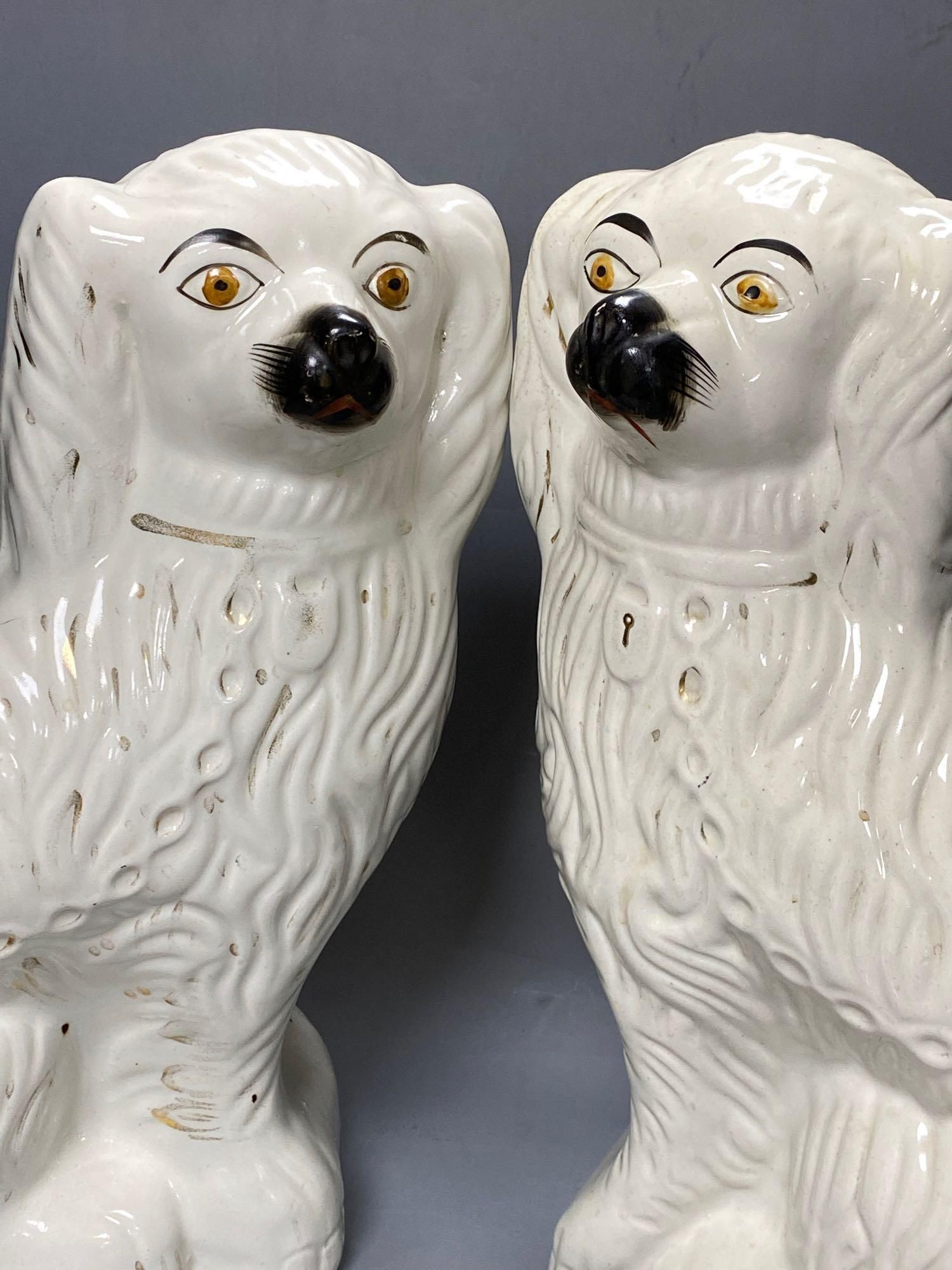 A large pair of Victorian Staffordshire pottery comforter spaniels, 39cm and a pair of Royal Doulton comforter spaniels, 14cm